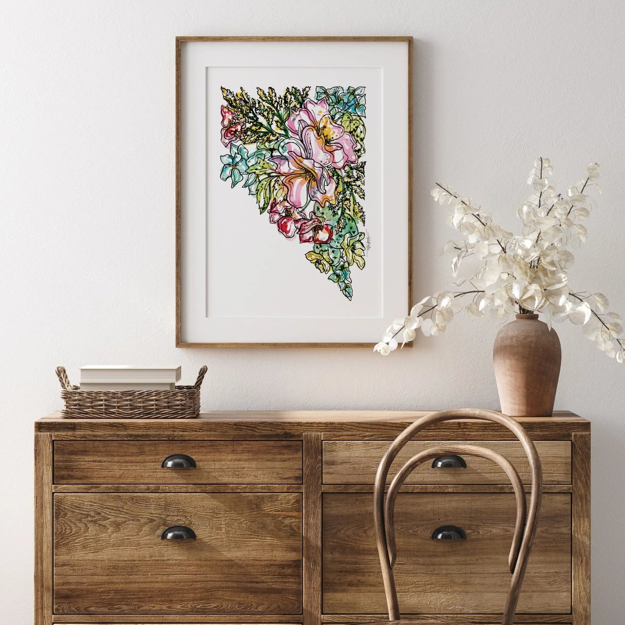 Framed Nevada floral art print with colorful watercolor flowers, displayed above wooden console table in home decor setting