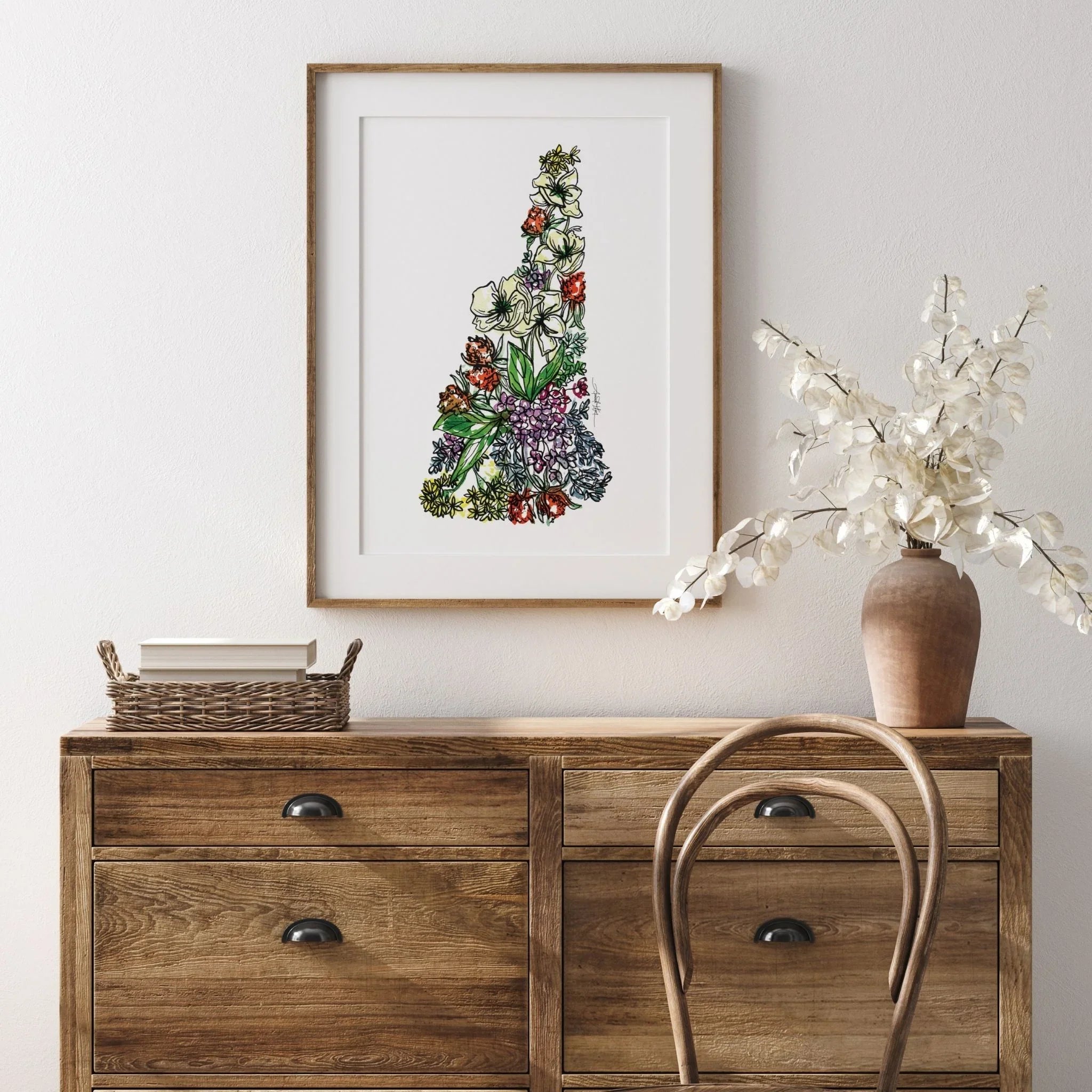 Floral New Hampshire state map art print in wooden frame, displayed above rustic dresser with vase and books