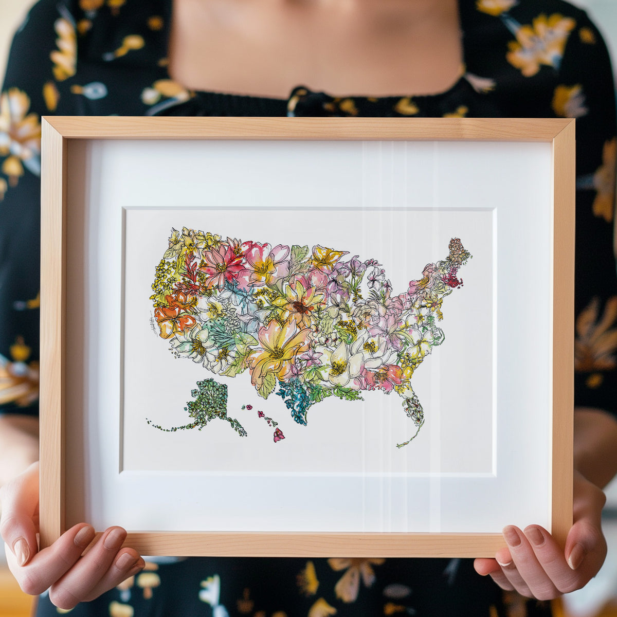 Person holding a framed colorful map of the United States with flowers