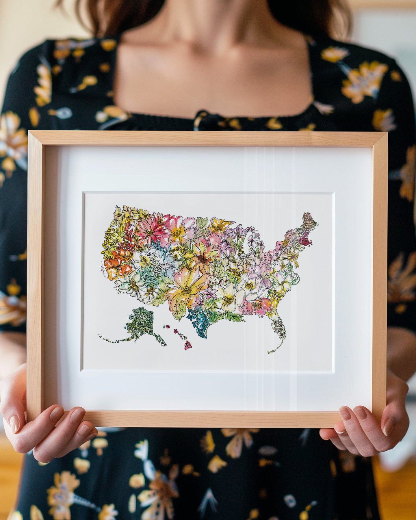 Person holding a framed colorful map of the United States with flowers