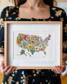 Person holding a framed colorful map of the United States with flowers